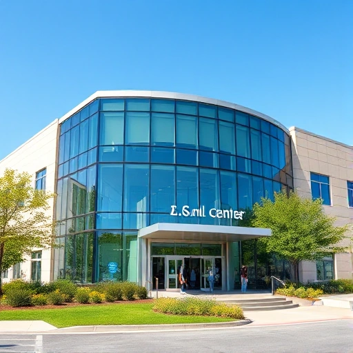 A modern medical center building with glass facade and green landscaping, showing the entrance with people entering, under a clear blue sky, smallHQ
